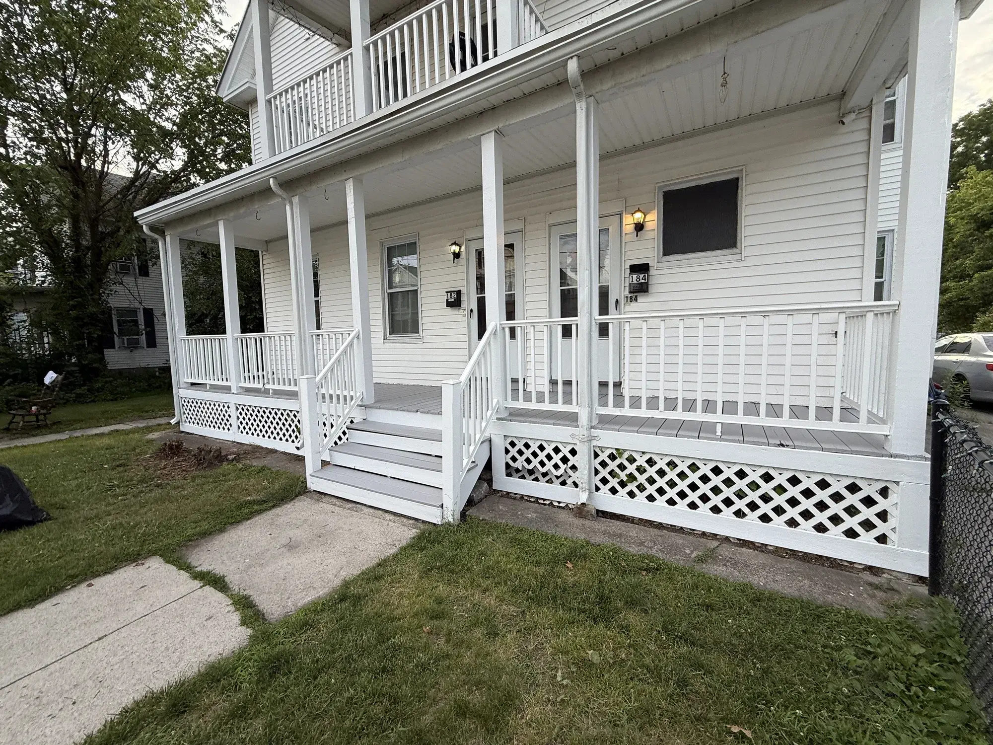 After: the same porch staircase with fresh white paint on the treads and skirting